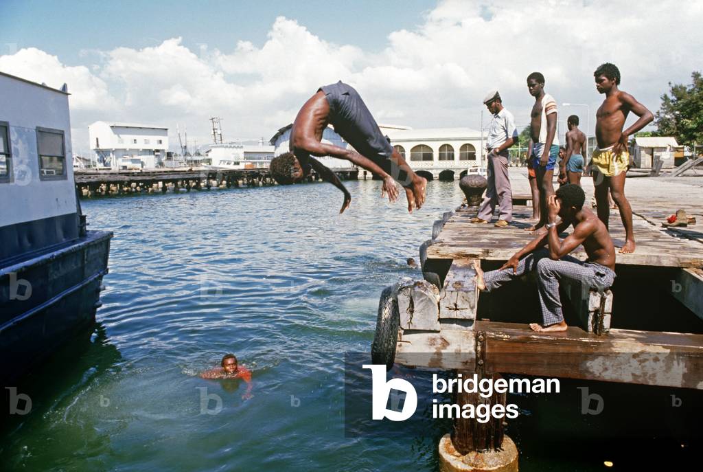 Jamaican kids swimming and diving in Kingston harbour, jamaica (photo)