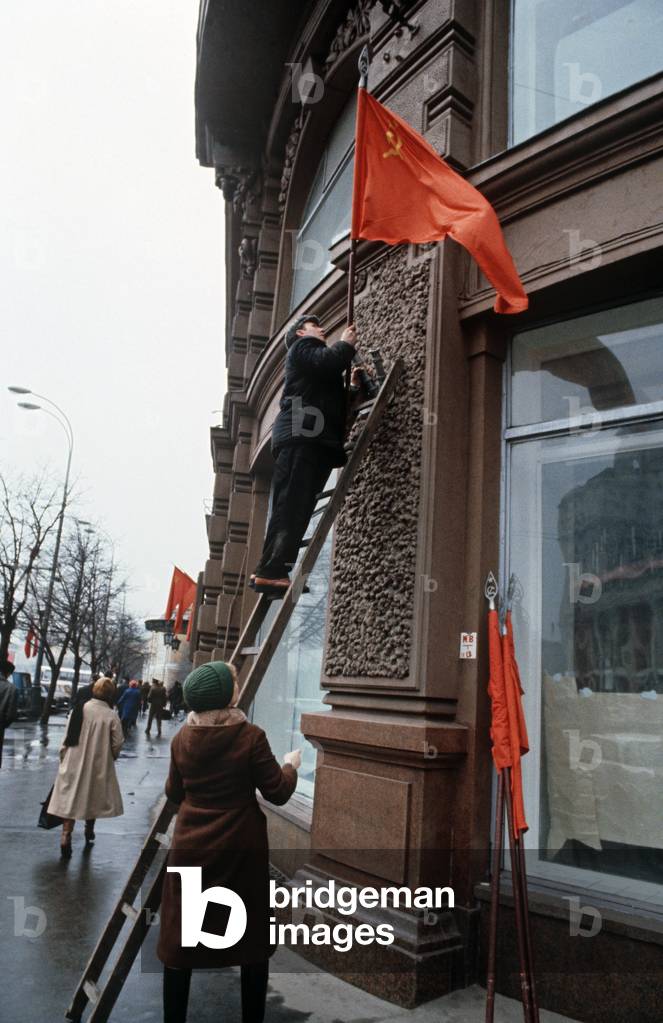 Taking down hammer and sickle Russian Communist flag after May day, Moscow, Russia (photo)