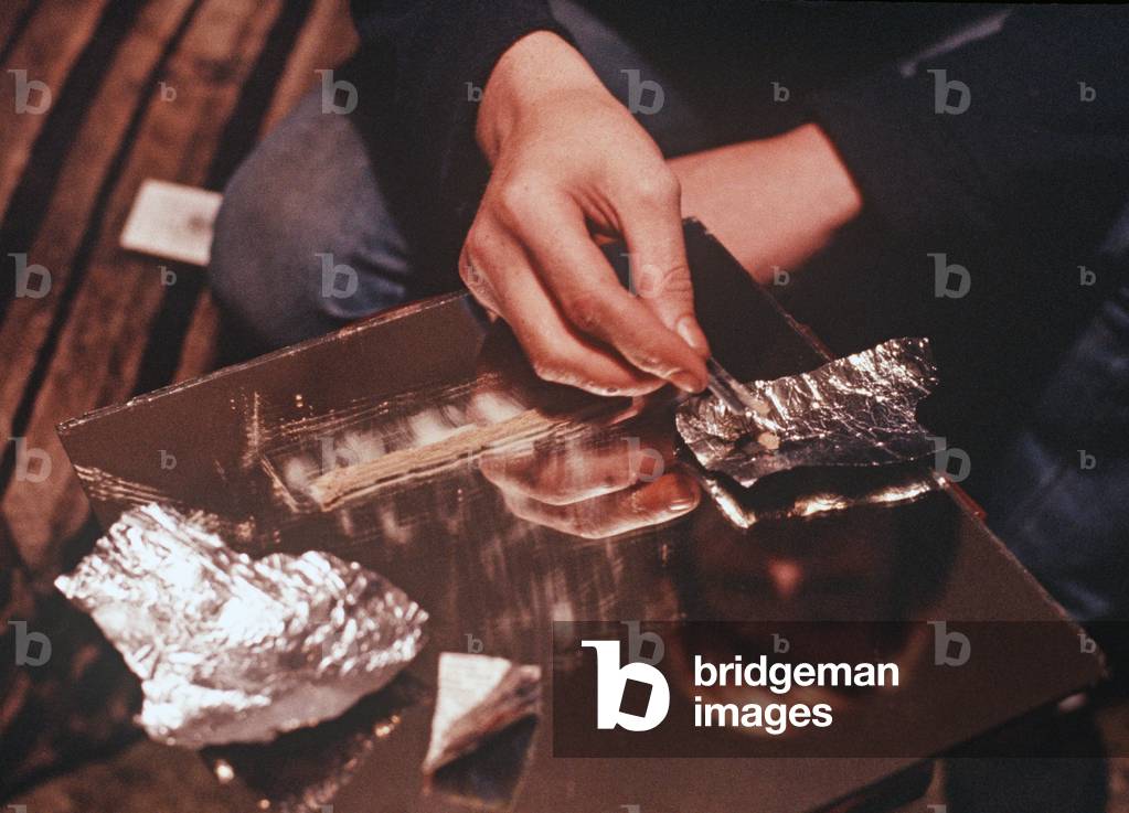 Drug addict cutting class A drugs,heroin, either to smoke or inject, Liverpool, UK (photo)