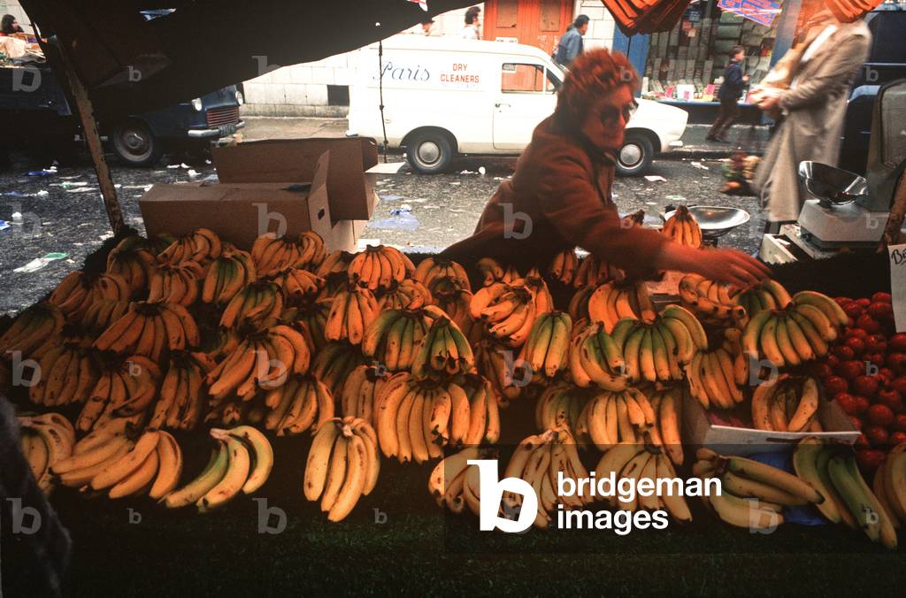 Selling bananas on a market stall in Portobello market in the 1970s, Notting Hill, London, UK, 1972 (photo)