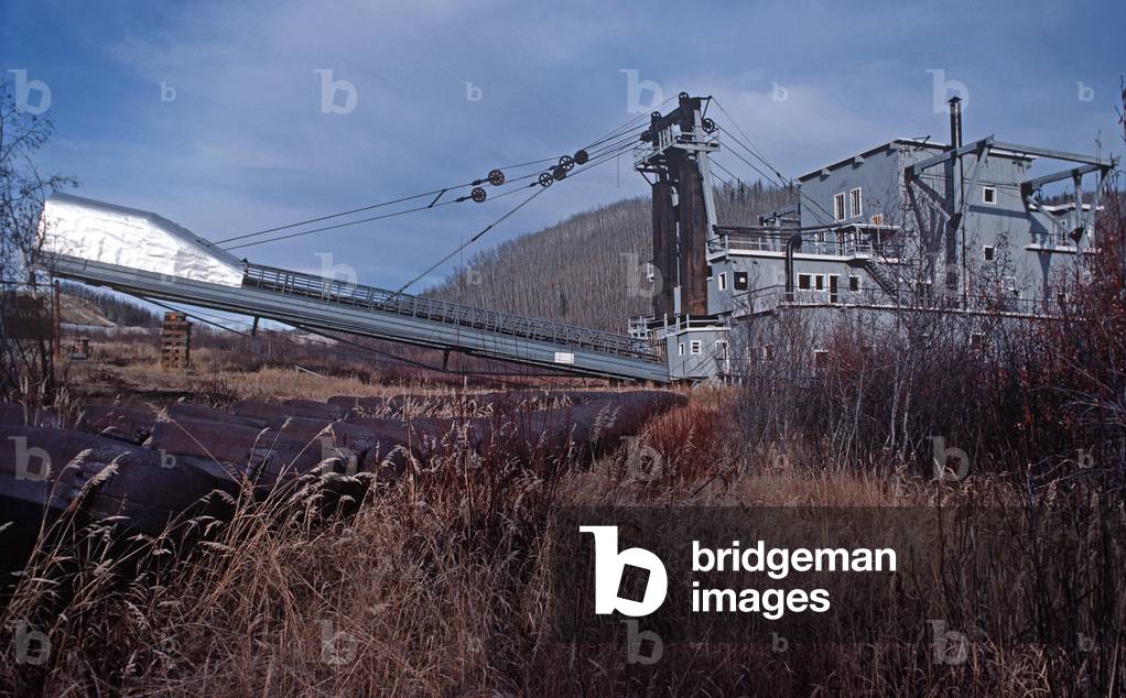 Dredger No. 4, a wooden-hulled bucketline sluice dredger that mined for gold on the Yukon River from 1913 until 1959, now located along Bonanza Creek Road, south of the Klondike Highway near Dawson City, Yukon Territorie, Canada (photo)