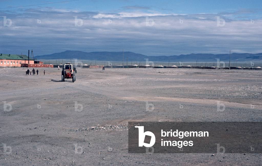 Tractor driving infront of Yurt village in Gobi-Altai, Mongolia, Asia