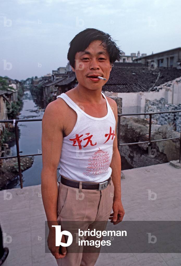 Hangzhou inhabitant in front of the many small canals running off the Grand Canal, Hangzhou, Zhejiang Province, China (photo)
