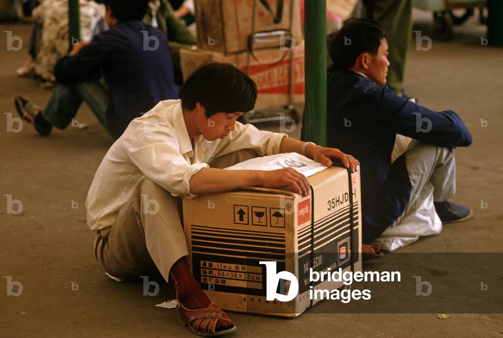 Passenger with new TV set waiting outside Hangzhou Railway Station, Hangzhou, Zhejiang Province, China (photo)