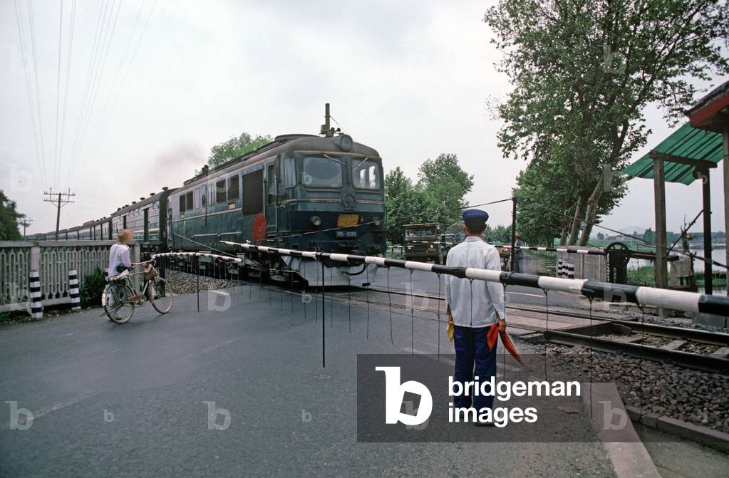 Commuter diesel train at railway crossing, Zhejiang Province, China (photo)