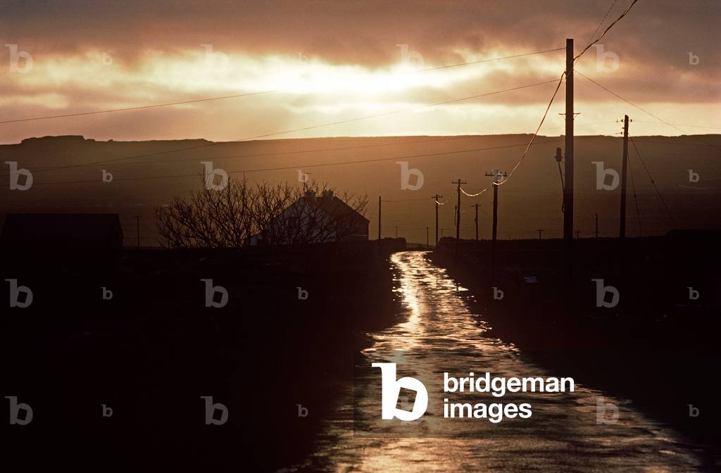 Road Bathed In Evening Light After Heavy Rain On Inishmore, Aran Islands Off The Coast Of Galway, Ireland. Referred To By W. B. Yeats When He Suggested That Playwright John Millington Synge Visit Visit The Aran Islands.  (photo)