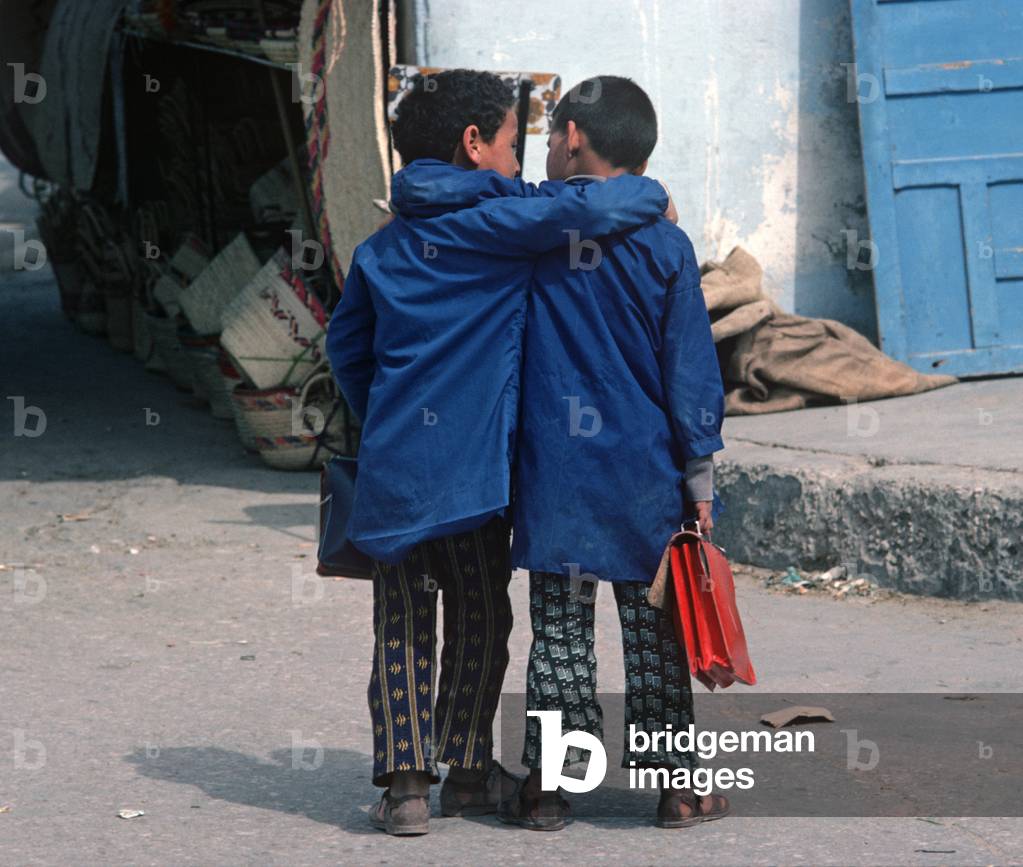 Arab Berber school friends in school uniform carrying school briefcases, Sahara desert town, South Tunisa, North Africa (photo)