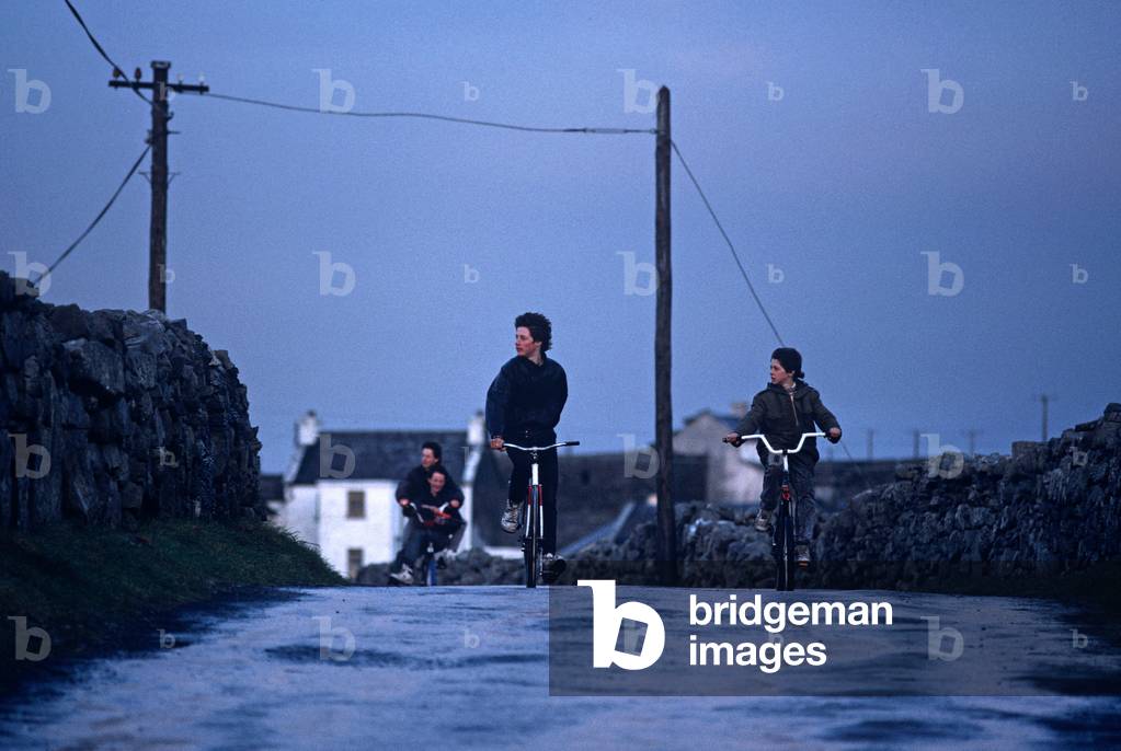 Young Aran Boys On Bicycles On Inishmore, Aran Islands Off The Coast Of Galway, Ireland. Referred To By W. B. Yeats When He Suggested That Playwright John Millington Synge Visit Visit The Aran Islands.  (photo)