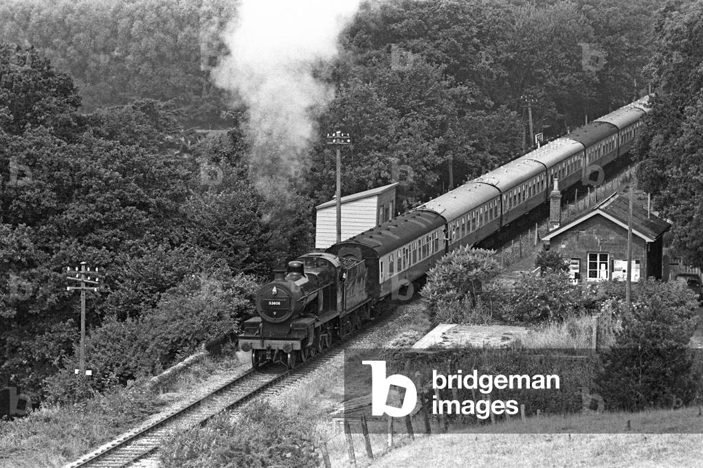 Steam train leaving Stogumber station on the West Somerset Heritage Railway, Somerset, England, UK, 1990 (b/w photo)