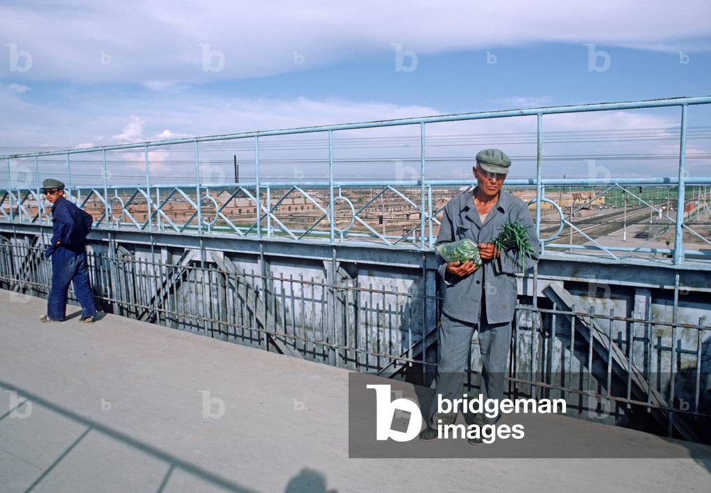 Man with vegetables, Daqing railway station, China (photo)