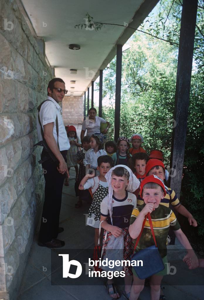 Armed Gush Etzion settler with kindegaten children in Gush Etzion settlement, Judaean Mountains, Israel, 1980s (photo)