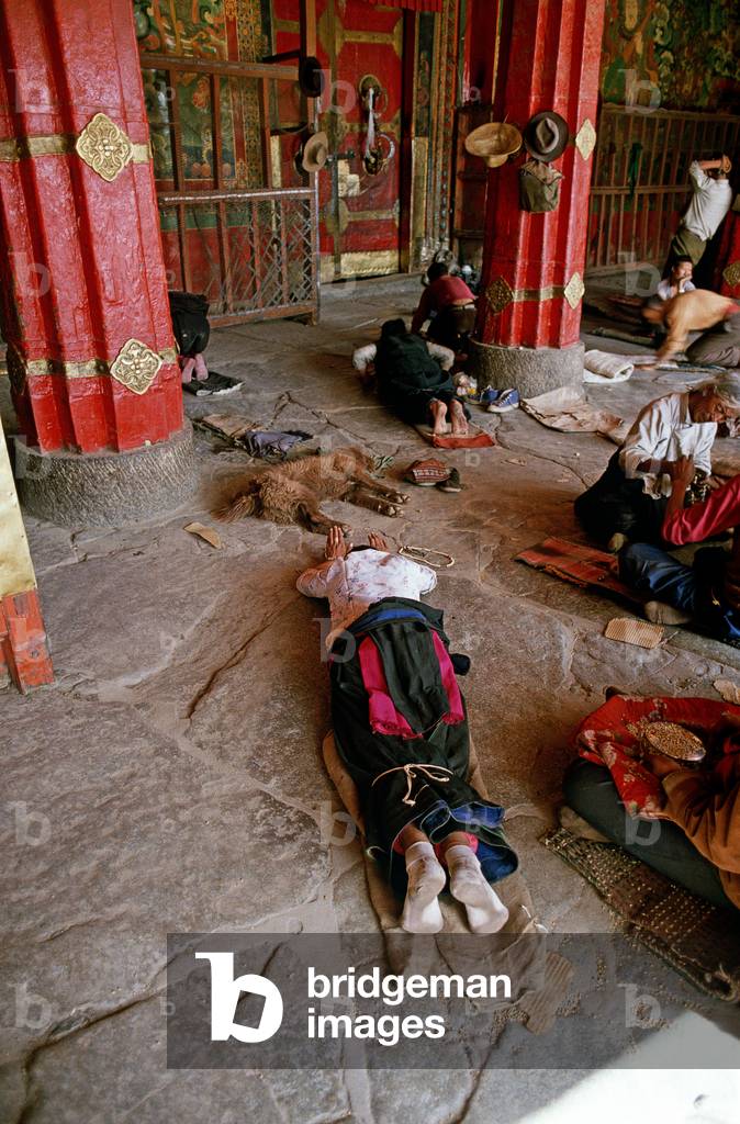 Buddhist pilgrims prostrating themselves in front of Jokhang Temple, Lhasa, Tibet (photo)