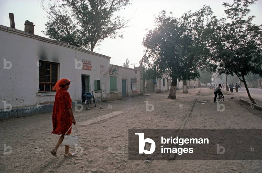 Uyghur woman walking through Turpan street, Xinjiang Province, China, 1985 (photo)