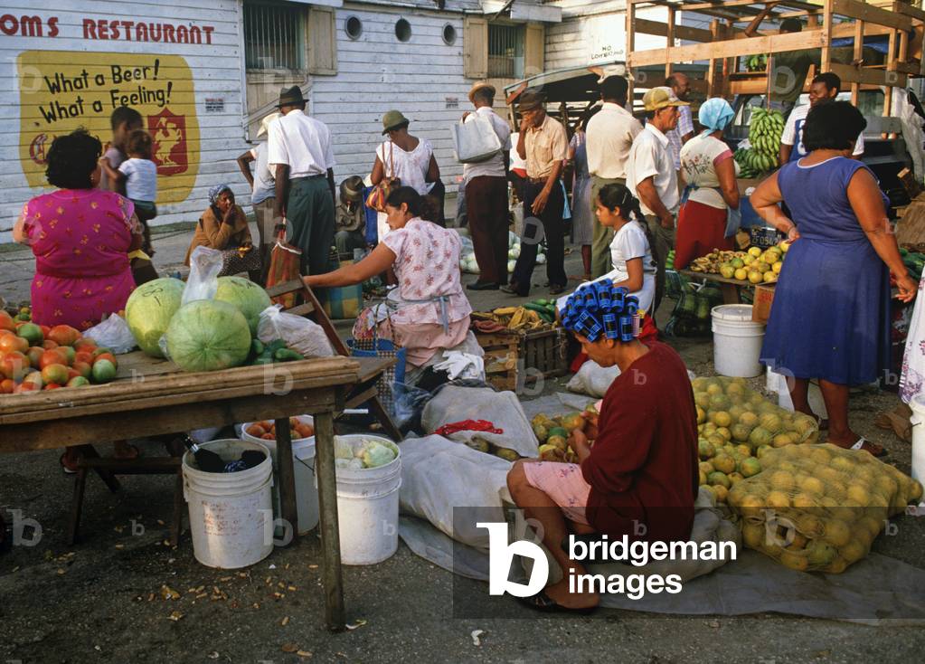 Belizean woman with blue hair curlers in Belize City fruit and vegetable market, Belize (photo)