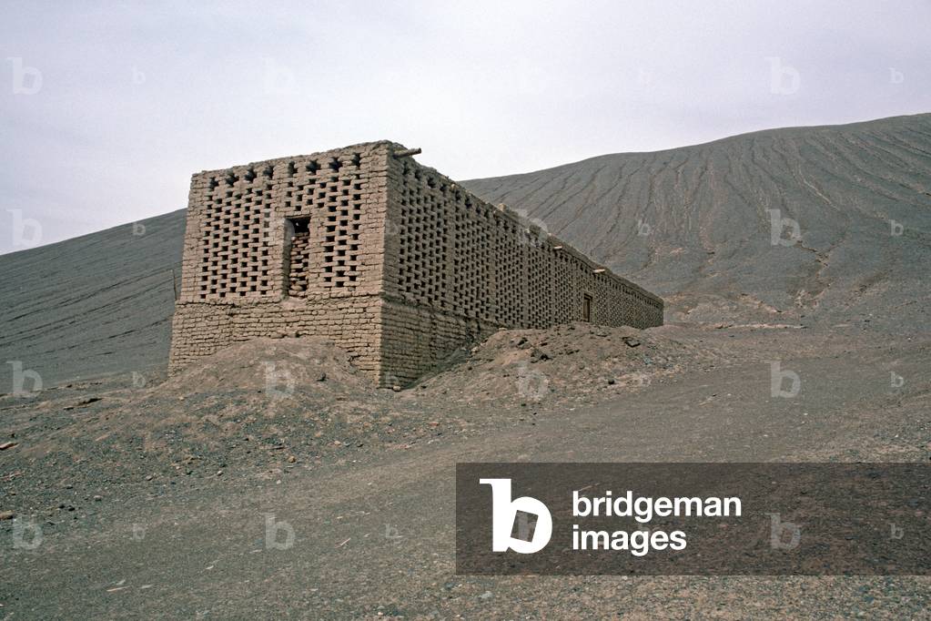 Grape storehouses made out of mud with gaps in bricks to air dry grapes in wine growing area around Turpan, Xinjiang Province, China, 1985 (photo)
