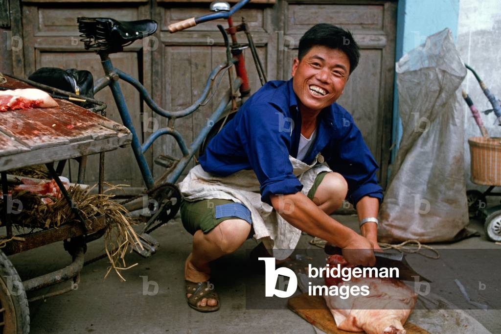 Street butcher cutting meat on pavement, Shaoxing, China (photo)