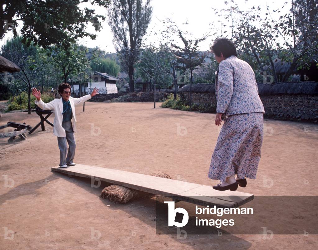 Korean women playing on see-saw  in park outside Seoul, South Korea, Asia (photo)