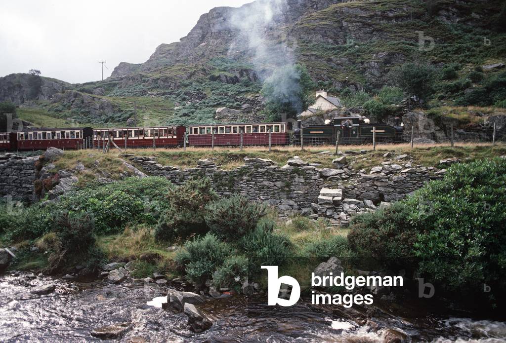 Steam locomotive passing through slate mining villages, Gwynedd, North Wales, 1990 (photo)