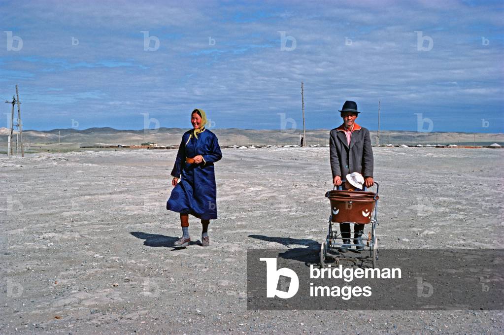 Mongolian couple and baby in pram walking in Gobi-Altai town, Gobi-Altai Province, Monglia, Asia