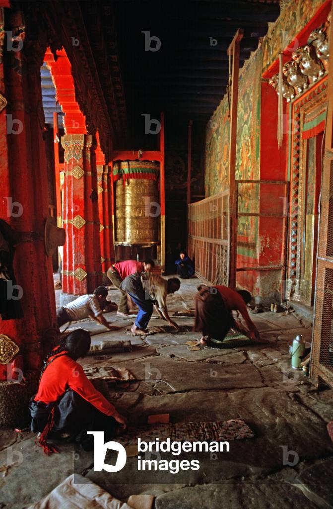 Buddhist pilgrims prostrating themselves in front of Jokhang Temple, Lhasa, Tibet (photo)