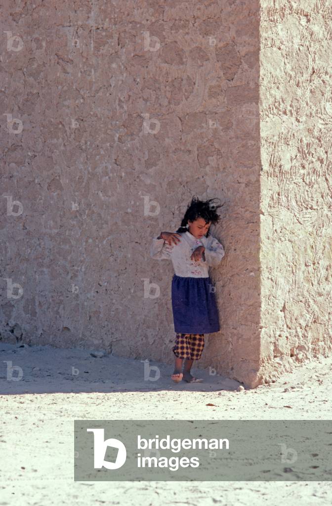 Young Arab Berger child practicing dance movements in shae of wall in South Tunisia, North Africa (photo)