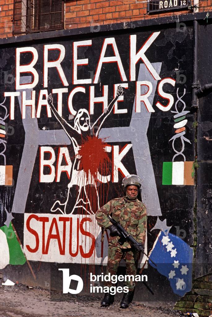 British Army Soldier standing in front of Republican Mural depicting Margaret Thatcher's stand against the Republican Hunger Strikers in the Maze Prison, 1982 (photo)