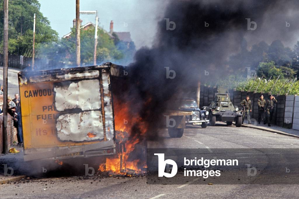 British Army attending burning hijacked vehicle in West Belfast during The Troubles, Northern Ireland, 1972