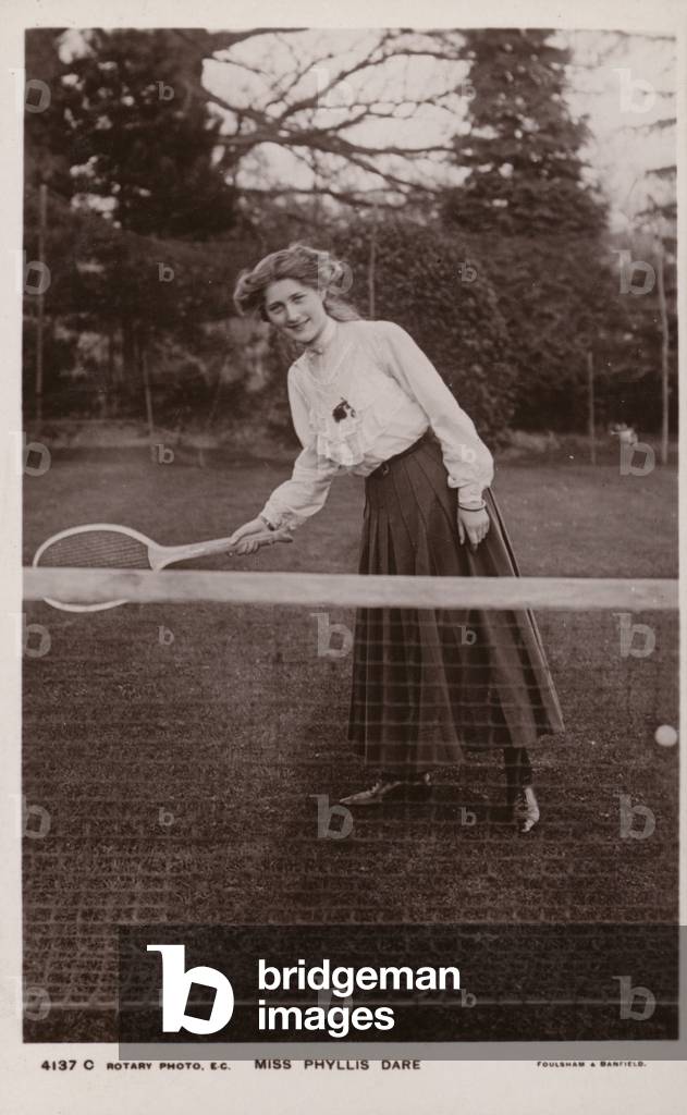 Miss Phyllis Dare, English singer and actress, playing tennis (b/w photo)