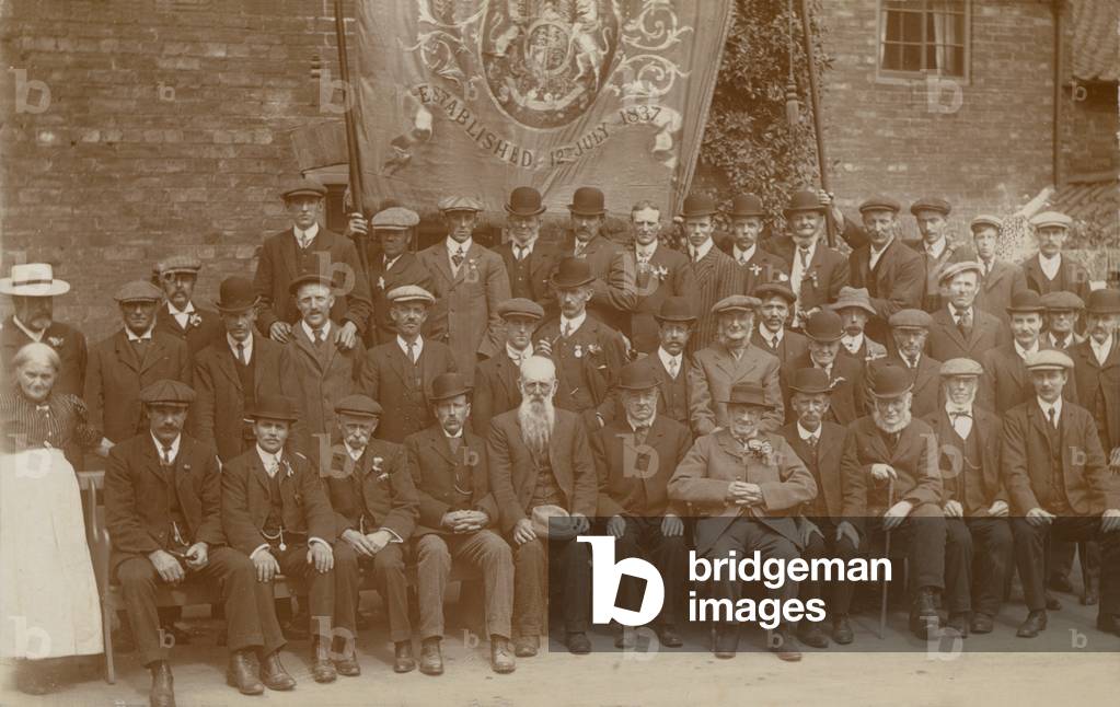 Group of men in front of a banner (b/w photo)