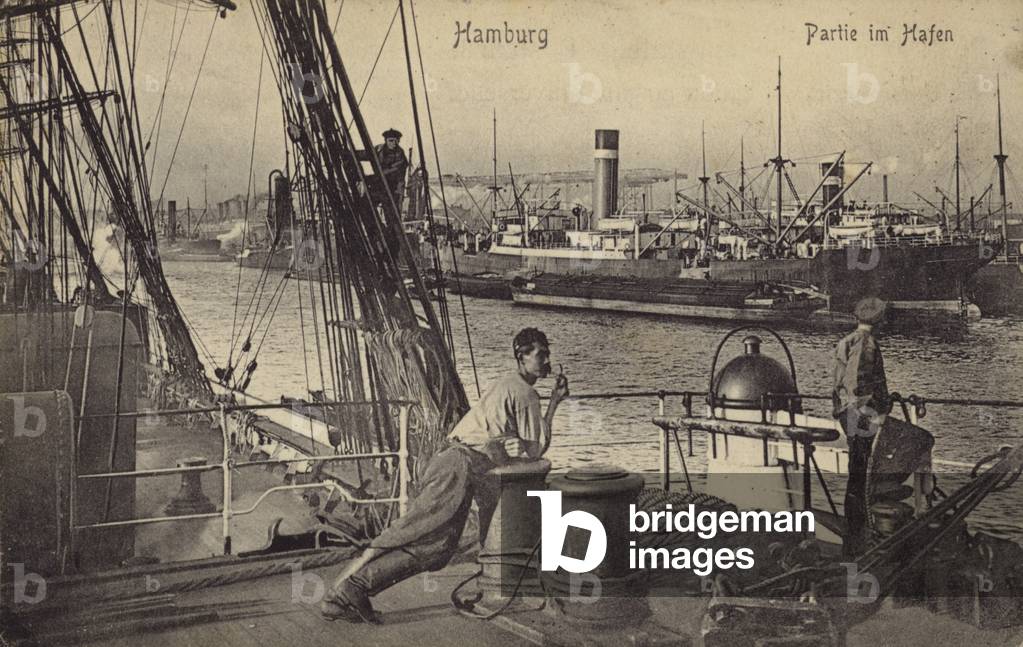 Postcard depicting a man leaning against a bollard in the docks of the Port of Hamburg (b/w photo)