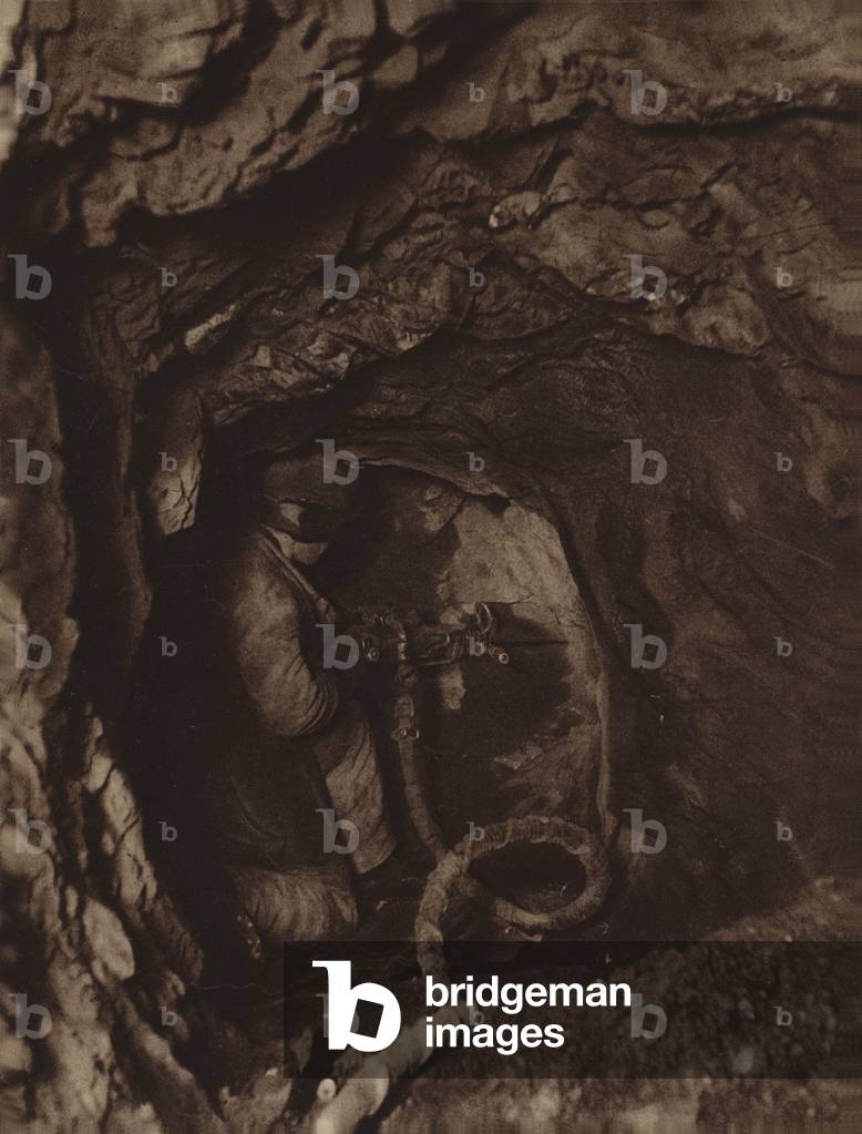 Soviet miner drilling for iron ore in the Telbes mine, USSR, 1931 (b/w photo)