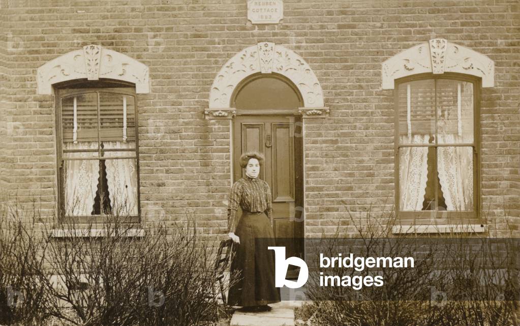 Woman standing outside Reuben Cottage (b/w photo)