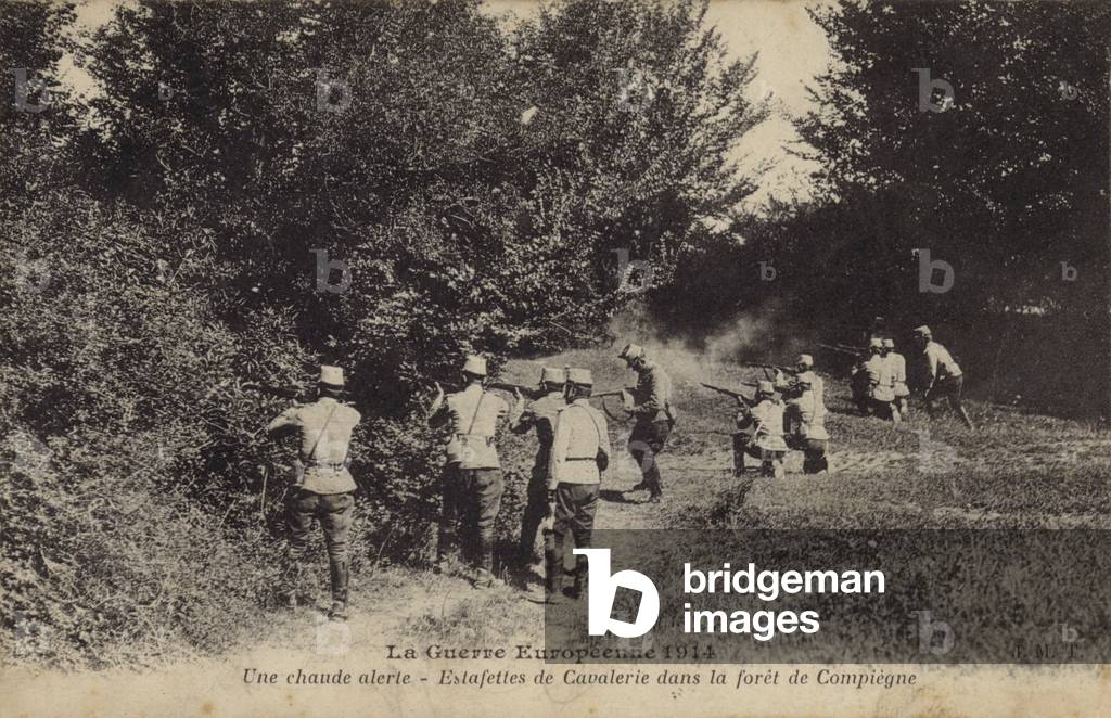 Dismounted French cavalry dispatch riders firing at the enemy, Forest of Compiegne, France; World War I, 1914 (b/w photo)