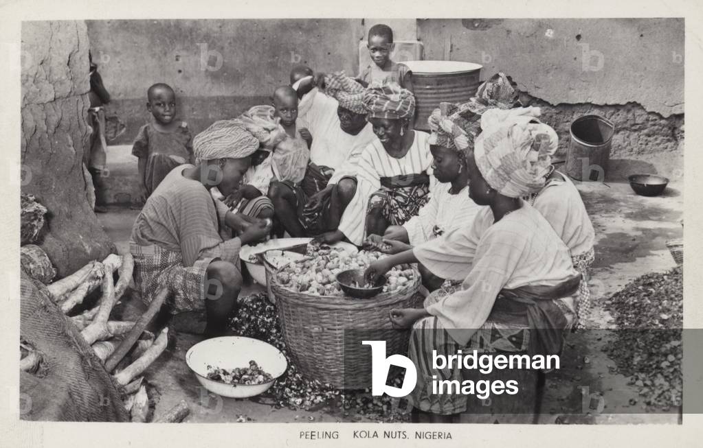 Women peeling kola nuts, Nigeria (b/w photo)