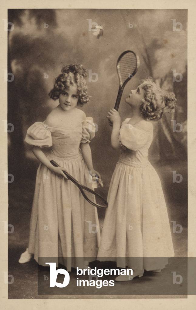 Two young girls playing badminton (b/w photo)