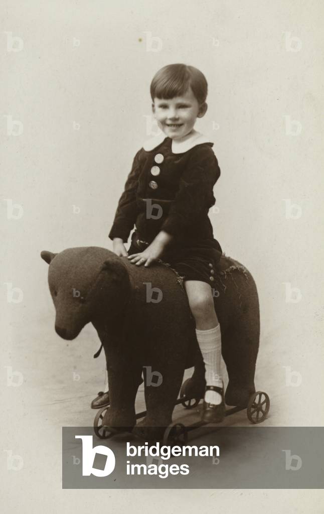 Boy on stuffed toy bear (b/w photo)
