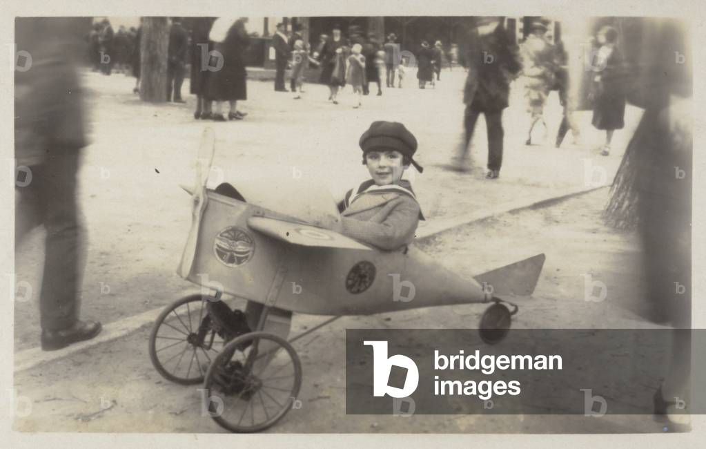 Boy in a toy aircraft (b/w photo)