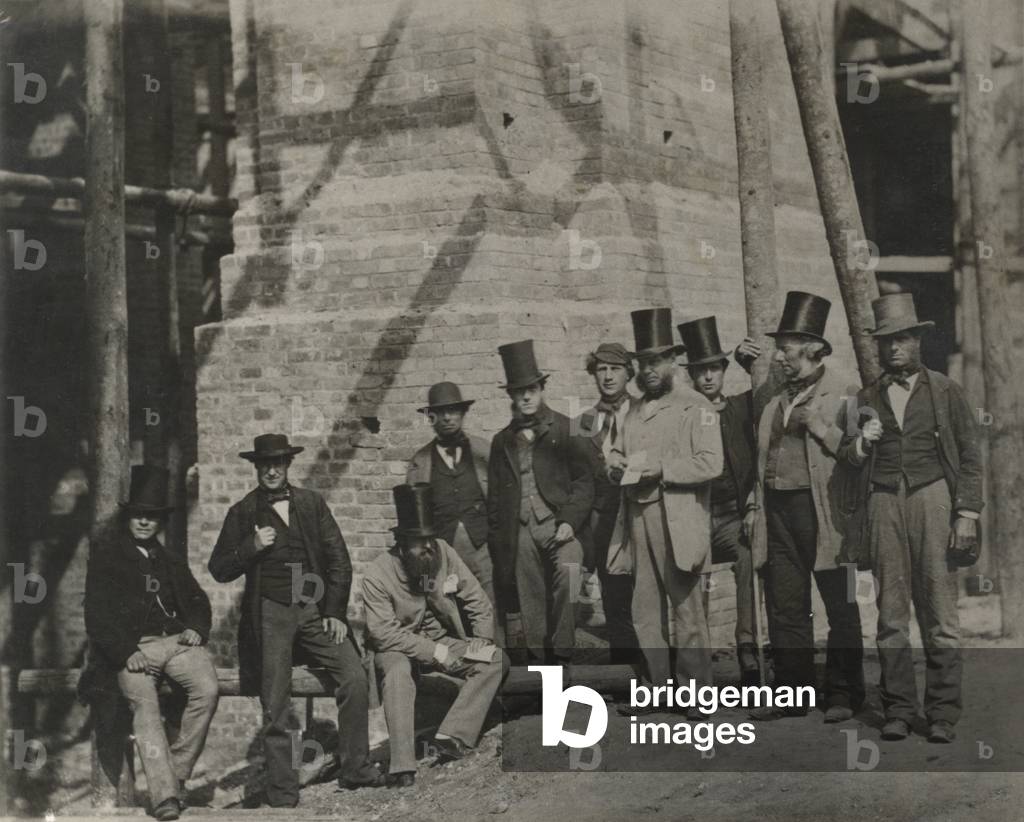 Group of men posing beside a bridge under construction or repair, 19th Century (b/w photo)