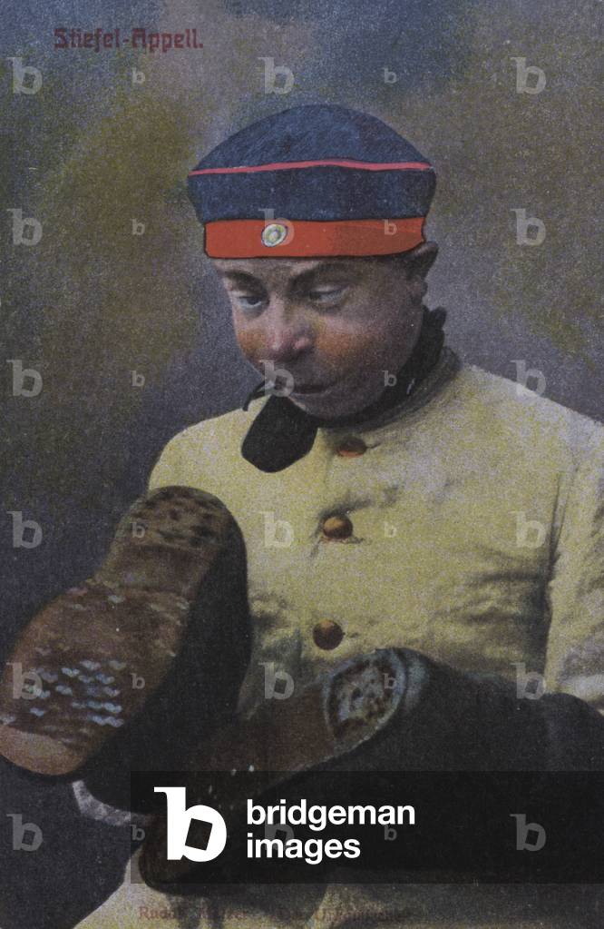 German soldier looking at the soles of his boots (coloured photo)