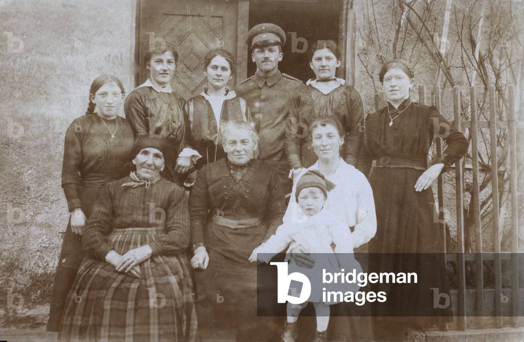 English soldier, WW1, with group of locals, Northern Europe, probably France (b/w photo)