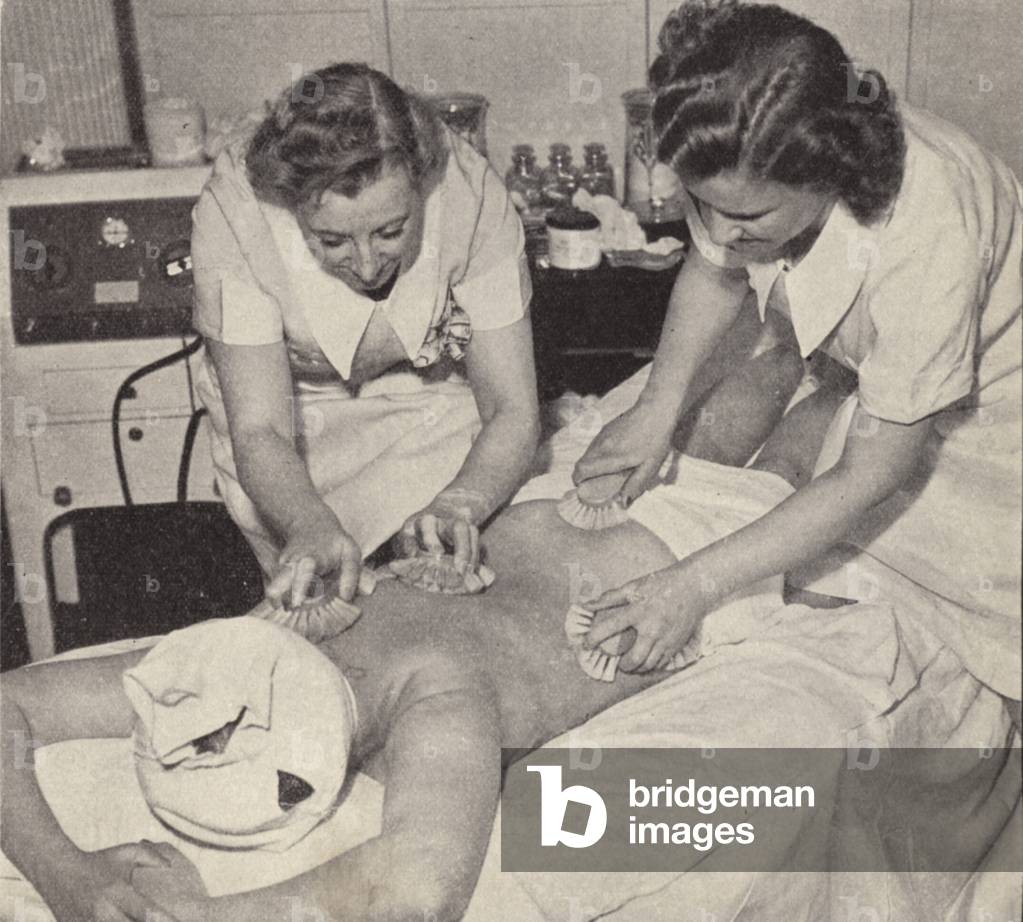 Women undergoing a body brushing beauty treatment (b/w photo)