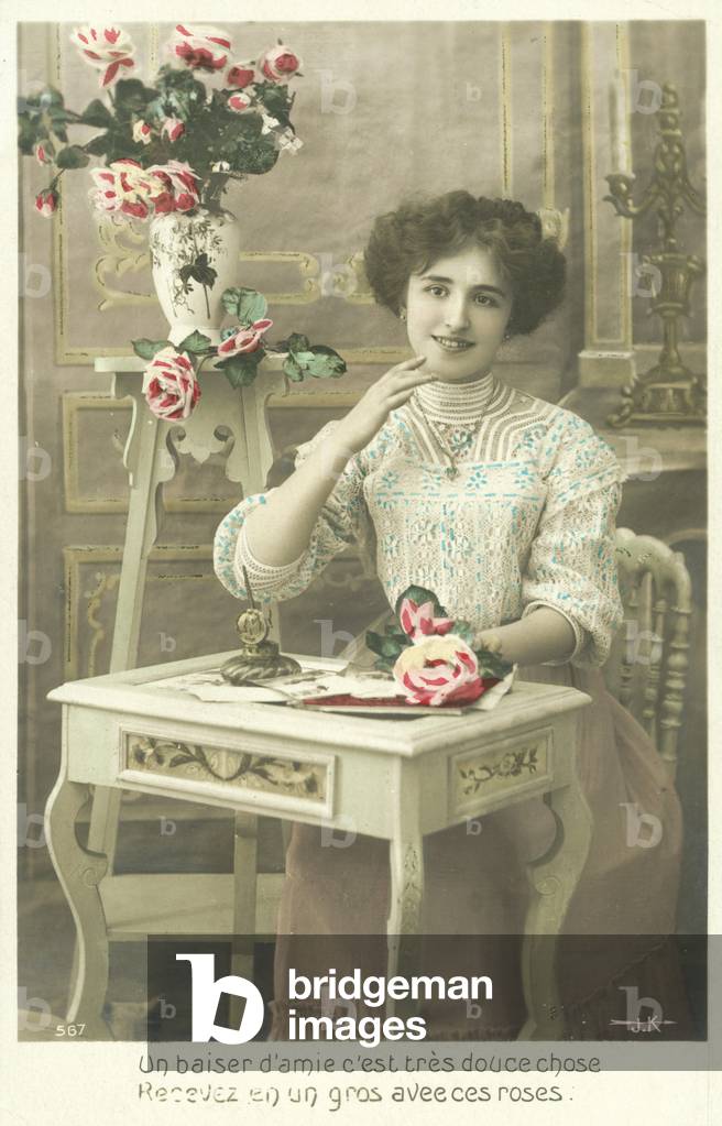 Woman writing a letter with roses (colour photo)