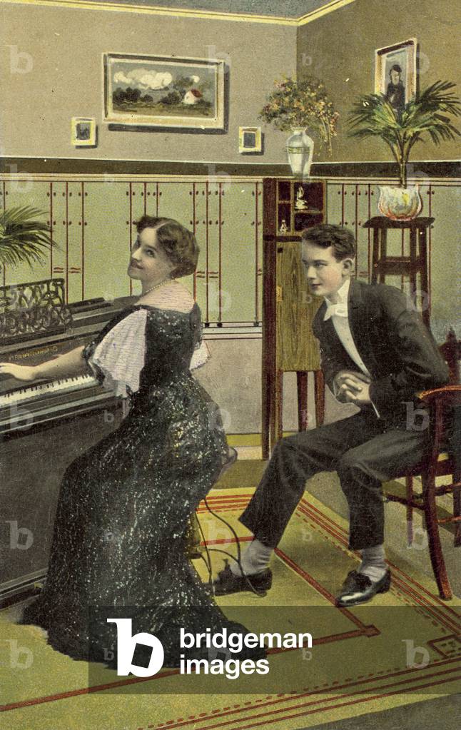Young man admiring pretty girl playing the piano (colour photo)