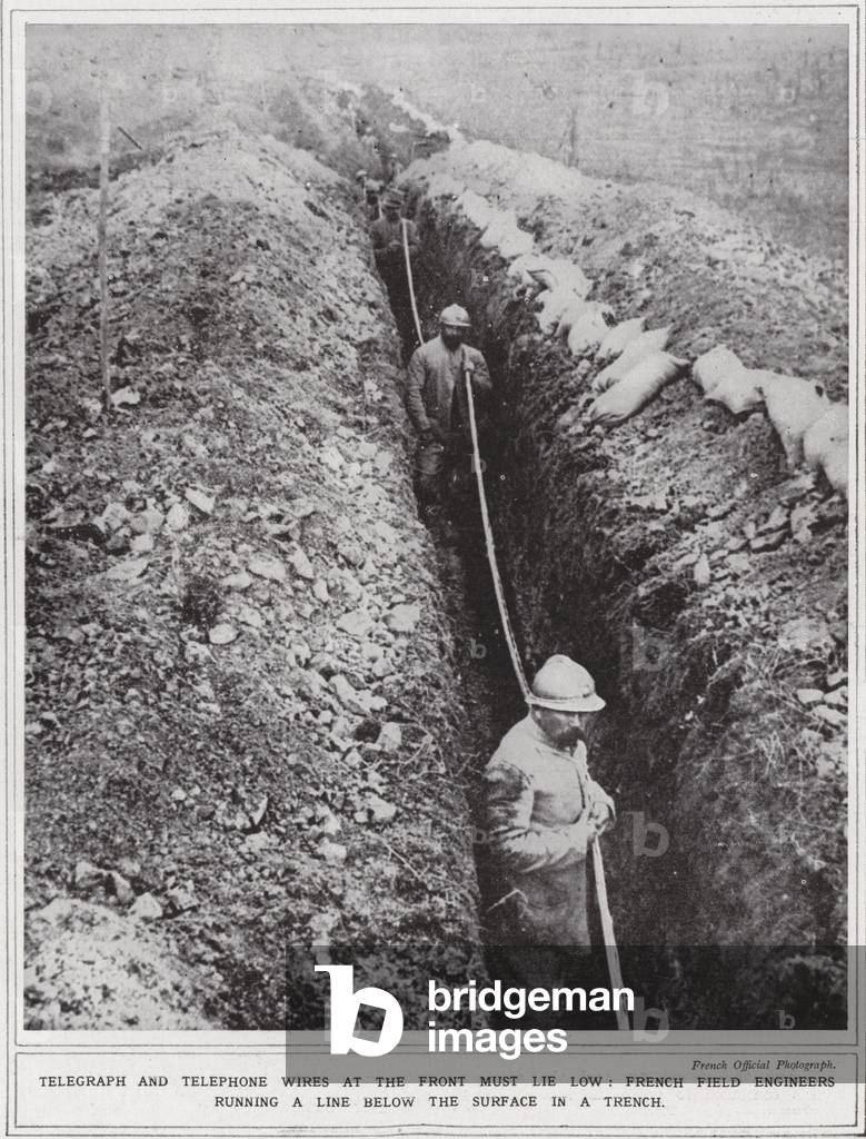 Telegraph and telephone wires at the front must lie low, French field engineers running a line below the surface in a trench (b/w photo)