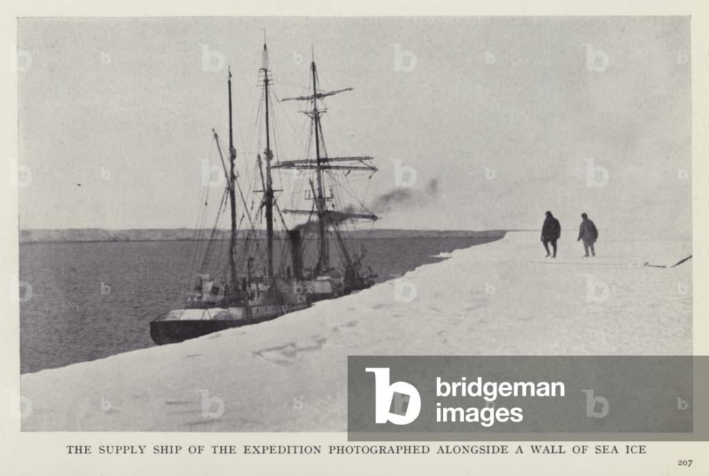 The supply ship of the expedition photographed alongside a wall of sea ice (b/w photo)
