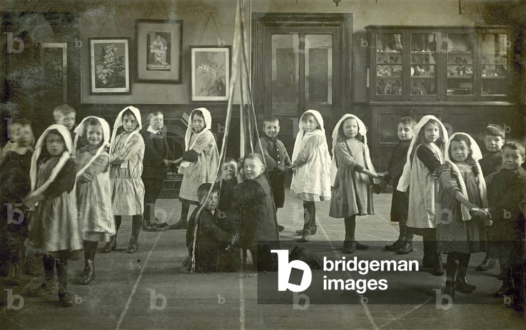 Children dancing around a May Pole (b/w photo)