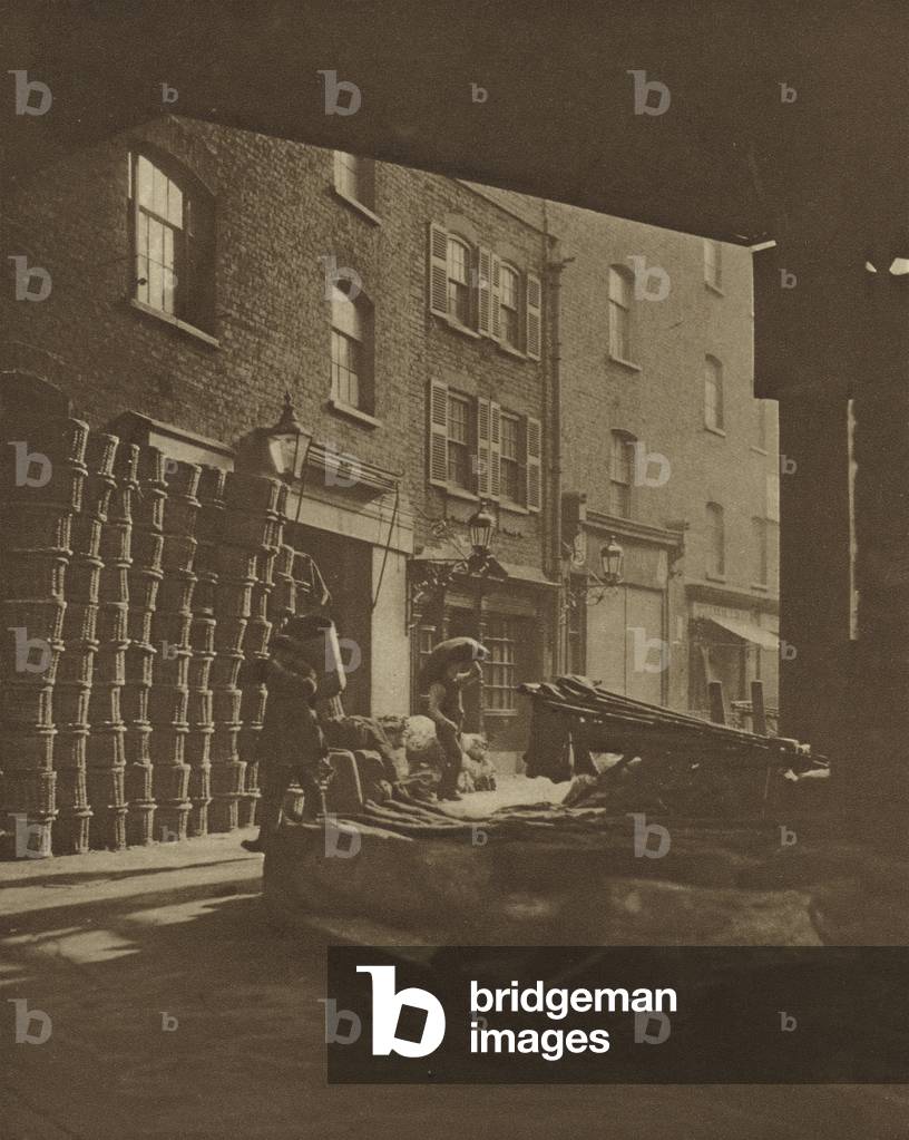 Fruit baskets piled against 18th Century houses at the Borough Market, Southwark (b/w photo)