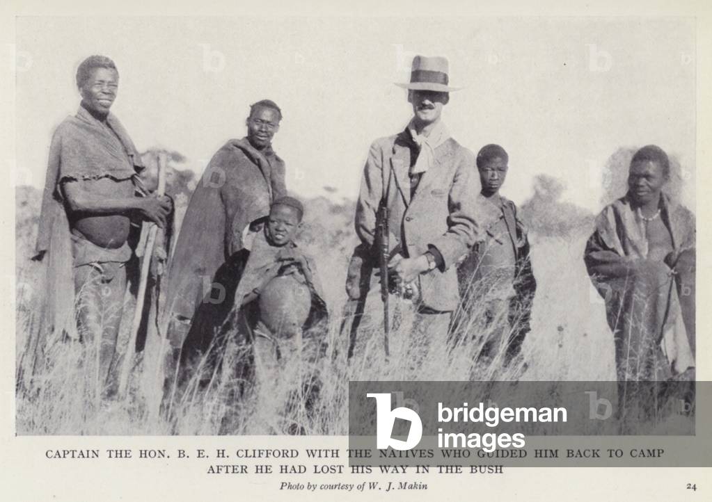 Captain the Hon B E H Clifford with the natives who guided him back to camp after he had lost his way in the bush (b/w photo)