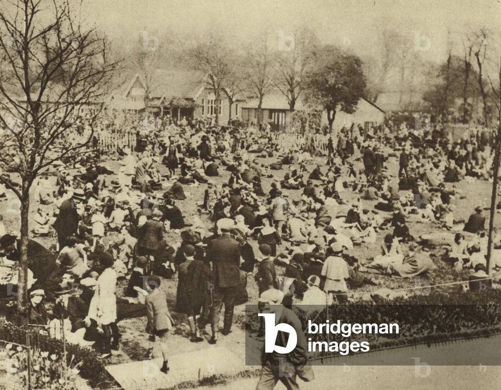 Bank Holiday visitors to London Zoo relaxing on the grass at lunchtime (b/w photo)