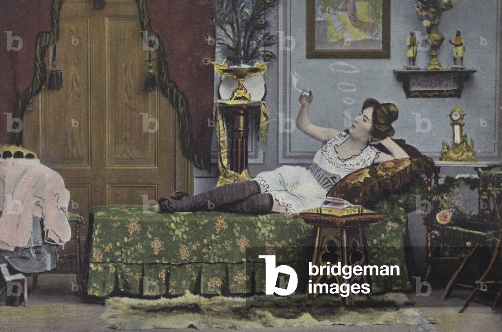 Woman smoking on a chaise longue (colour photo)